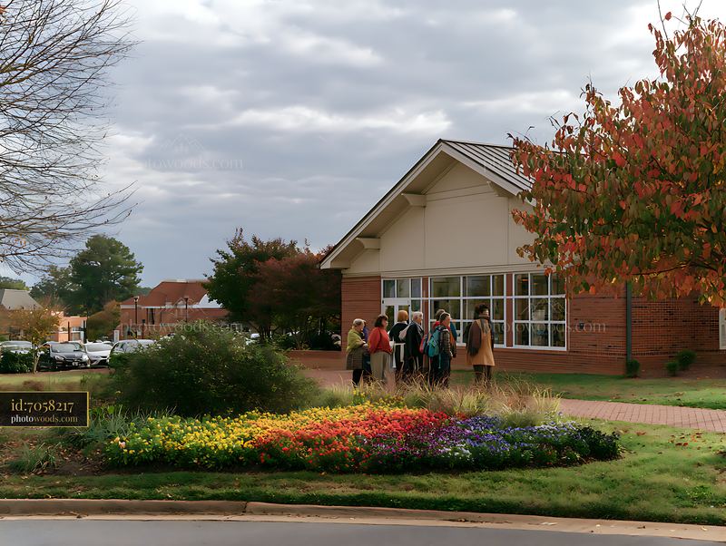 Colorful flower bed outside a building under a cloudy sky