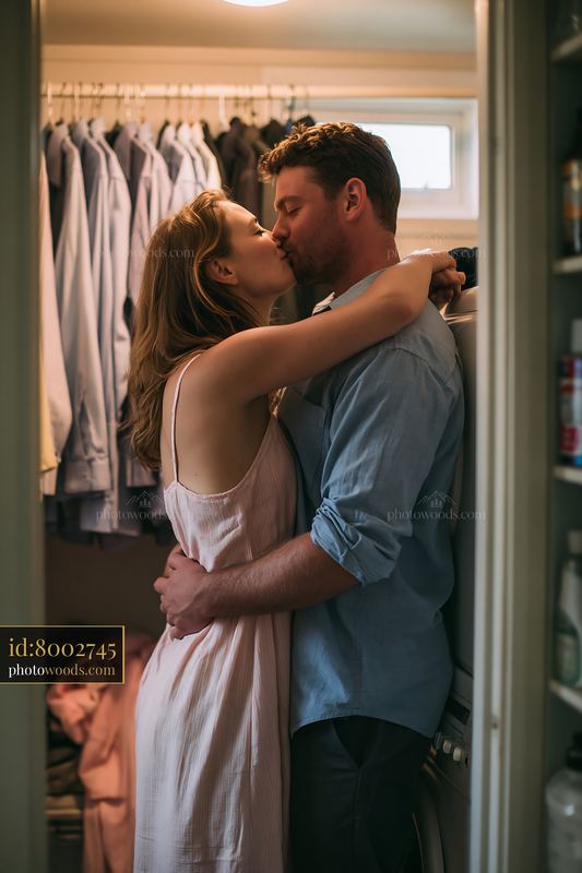 Couple kissing in a home closet before work