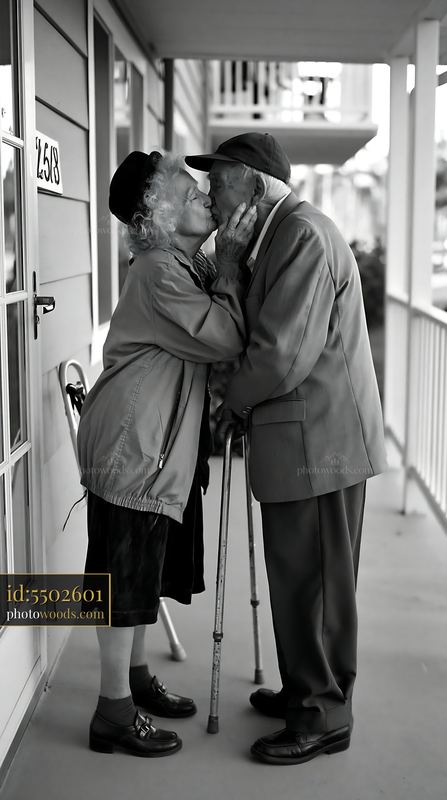 Elderly couple kissing on a residential porch