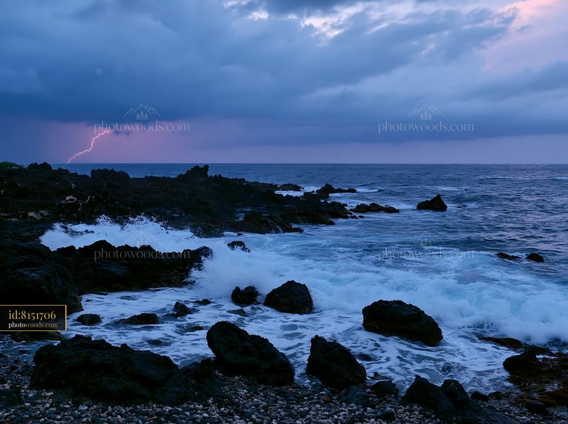 Coastline with lightning over ocean during stormy weather