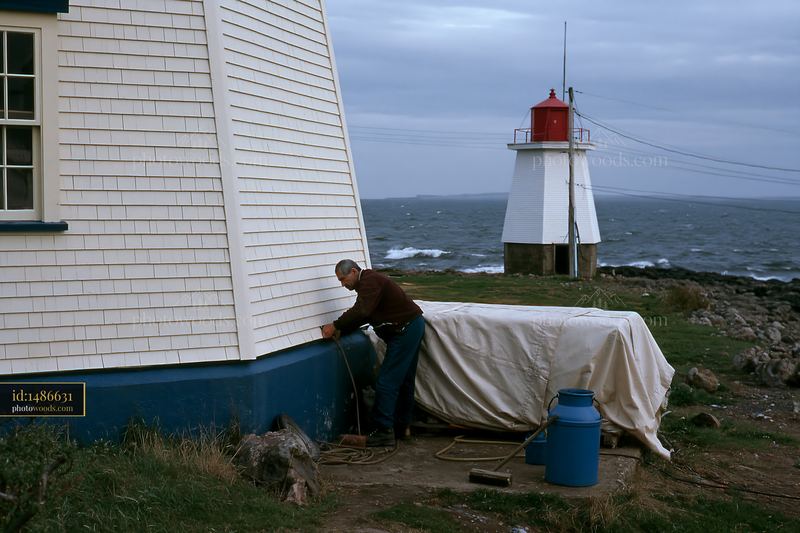 Lighthouse Maintenance Worker Cleaning Exterior by the Coast