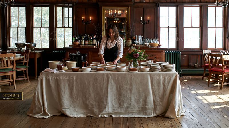 Rustic buffet setup with linen-covered table and one server