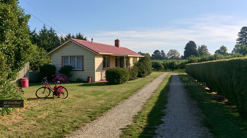 Country home with bicycle beside a gravel driveway