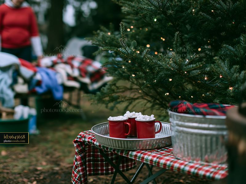 Cocoa with marshmallows beside a decorated Christmas tree