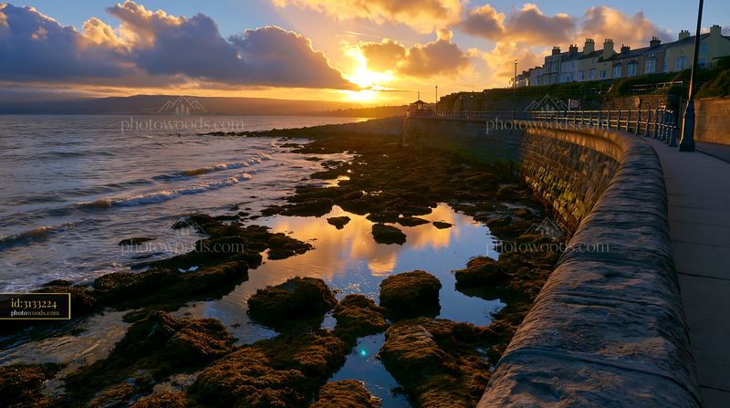 Coastal sea wall and rocky shoreline at sunset