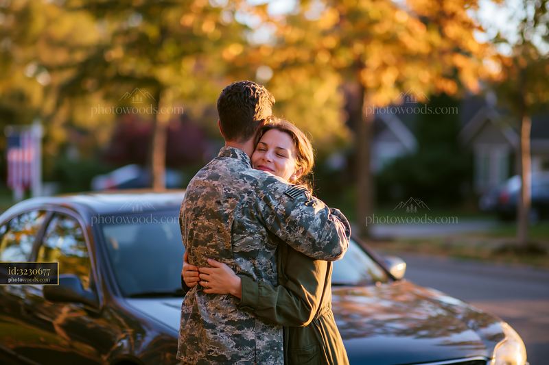 Service member embracing woman outdoors at homecoming