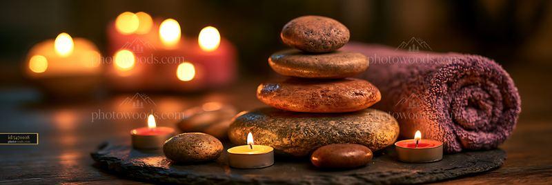 Relaxing spa setup with stones, candles, and towel