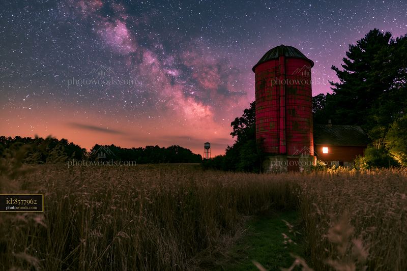 Starry night over a rural silo with shining stars and fields