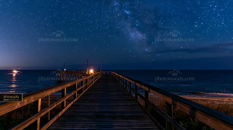 Starry night over a coastal boardwalk view