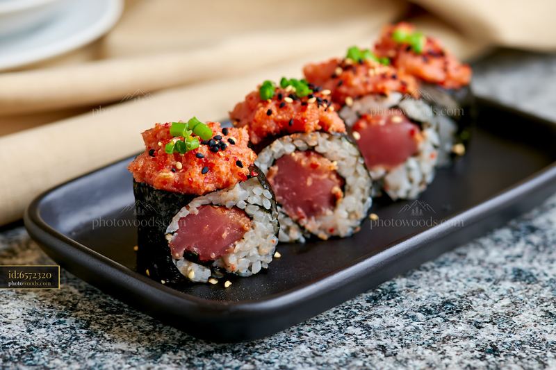 Spicy tuna roll close-up on a black plate