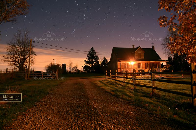 House under stars with gravel driveway in countryside setting