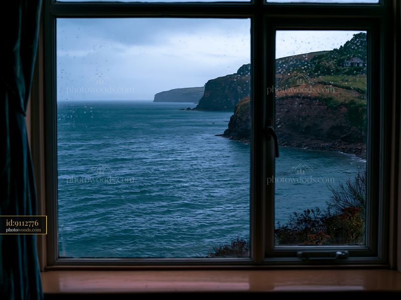 View from a window overlooking coastline with rocky peninsula