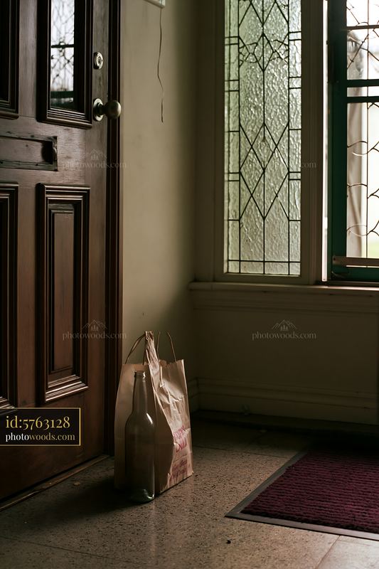 Empty bottle by the door after a social gathering in a home