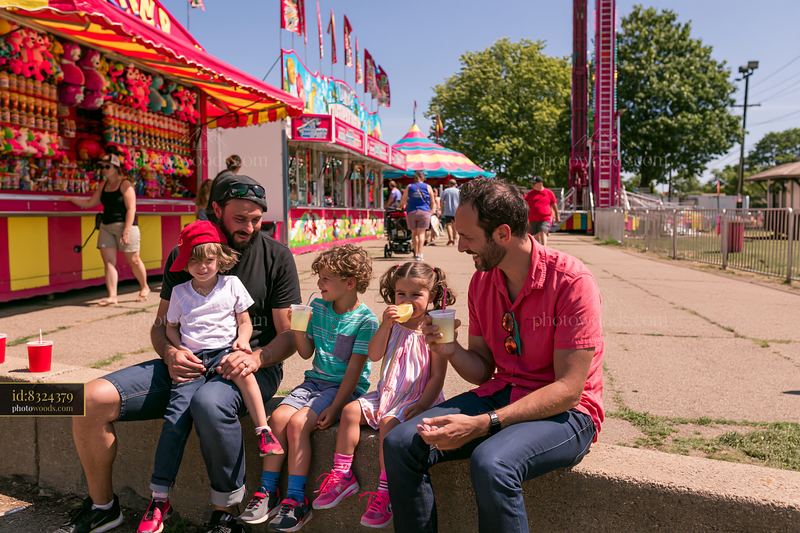 Family enjoying food at a colorful fairground
