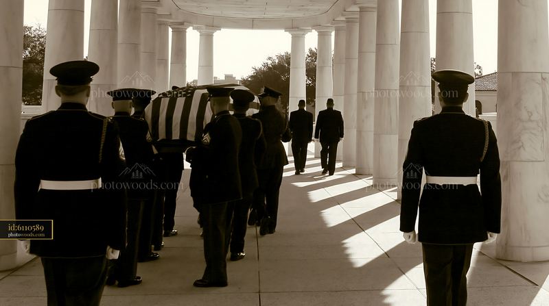 Military honor guard carrying a flag-draped coffin through a colonnade