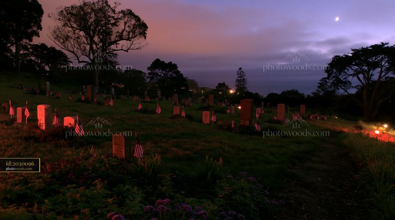 Veteran graves with small US flags at night in a serene setting