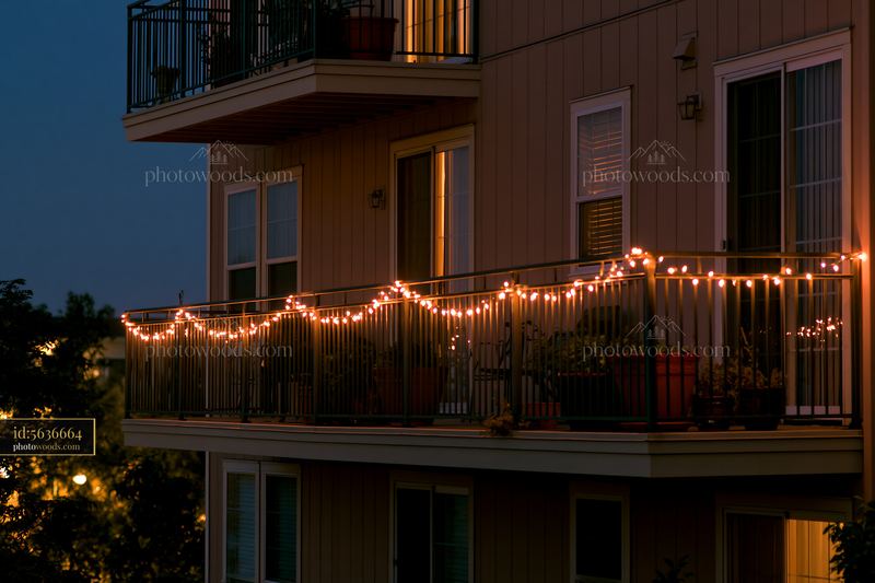 Christmas lights decorating a residential balcony at dusk