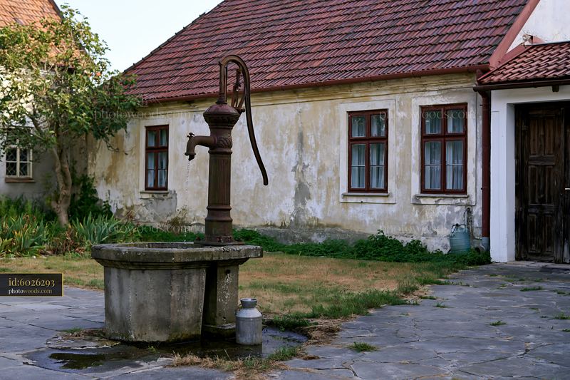 Old Cottage with Weathered Facade and Hand Pump