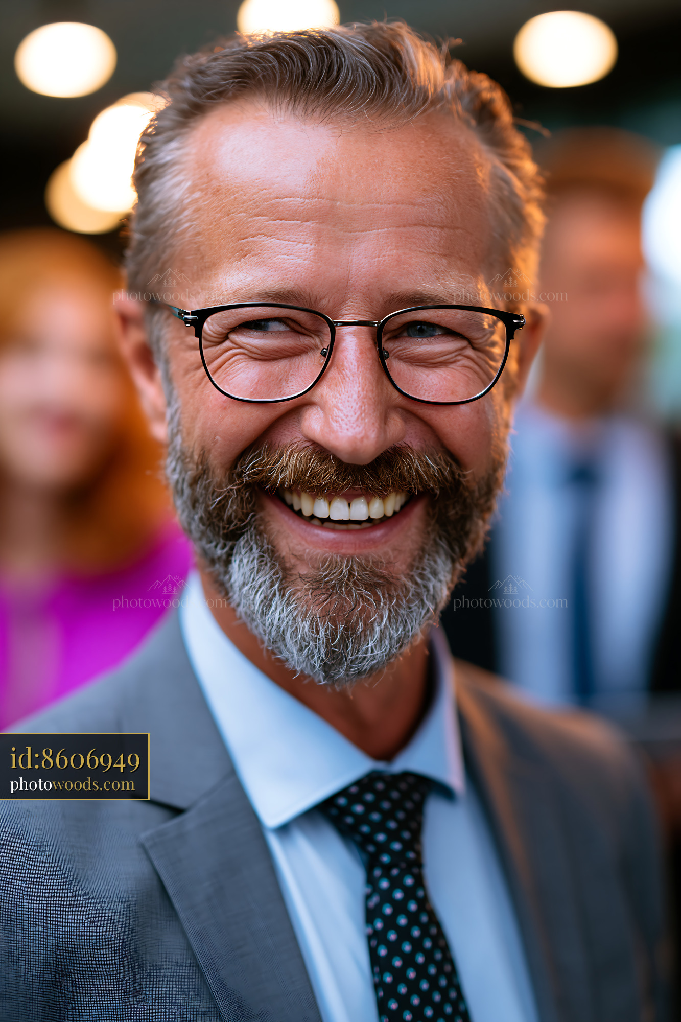 Man Smiles While Wearing Glasses and Standing in a Crowd