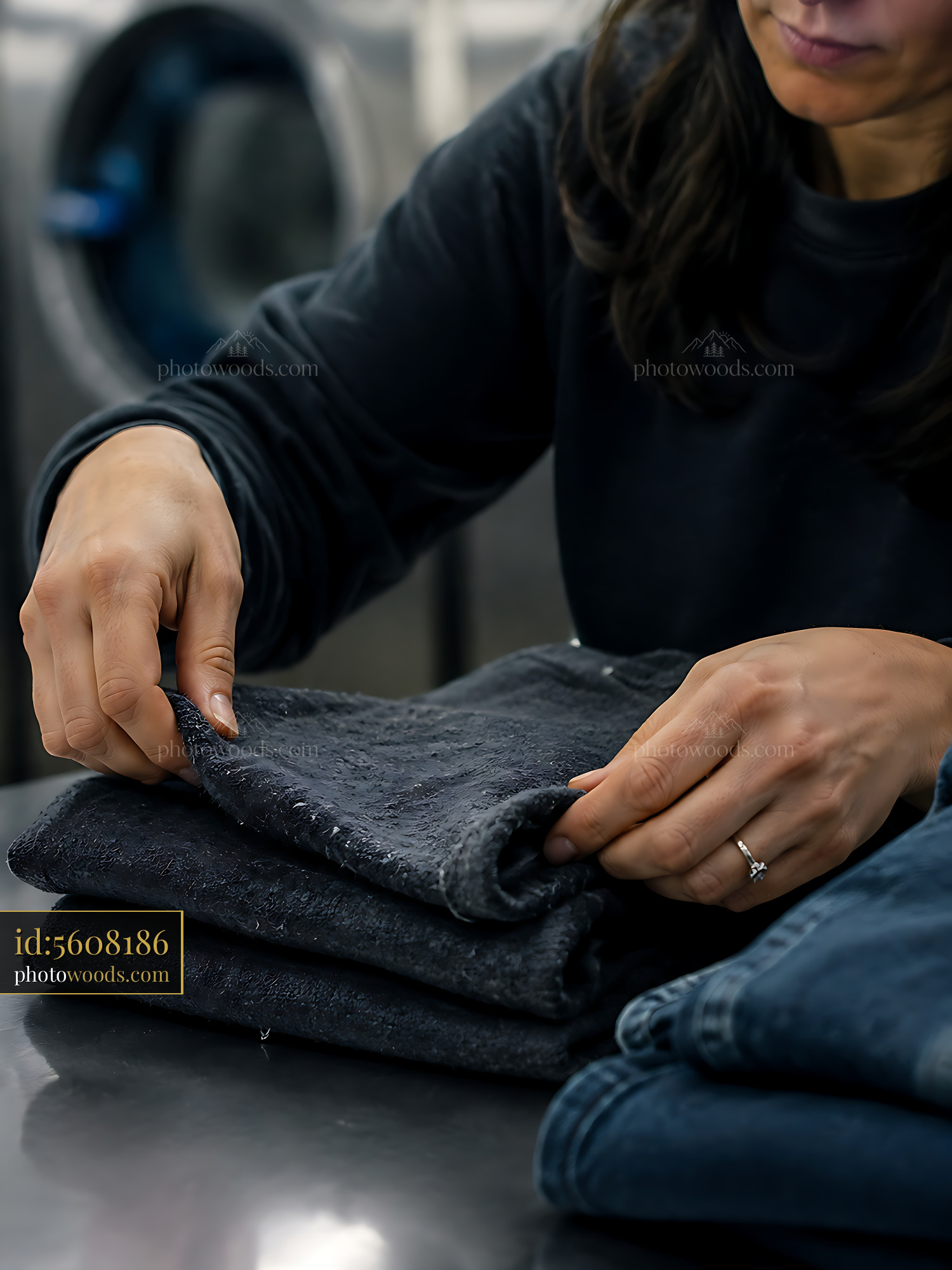 Woman Folding Denim Clothing in a Laundry Facility