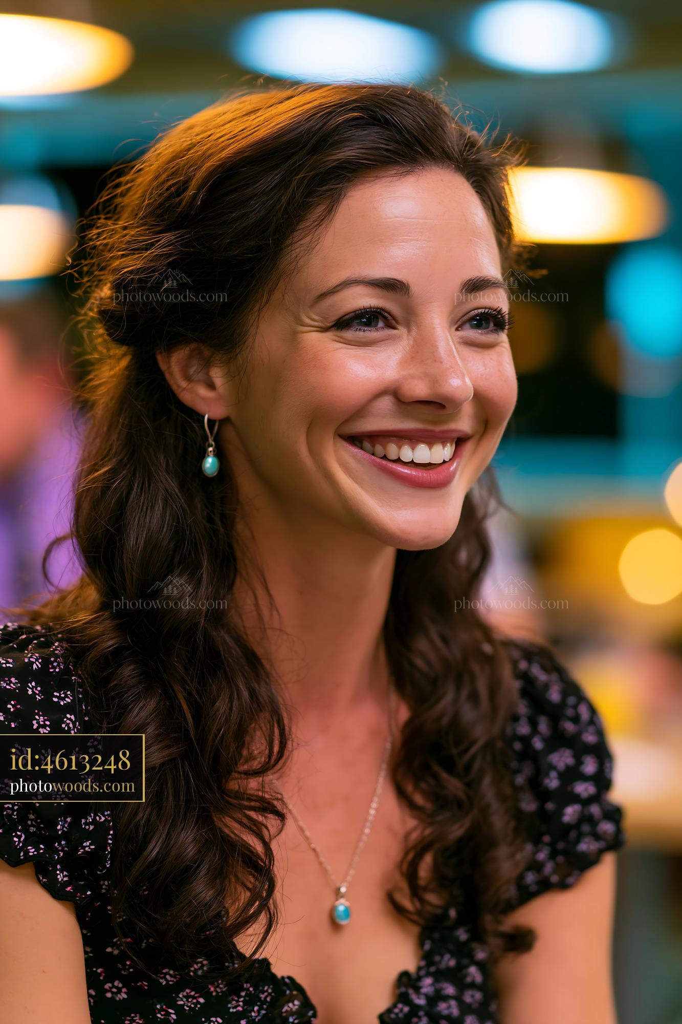 Woman Smiling While Sitting Indoors With Soft Lights Around