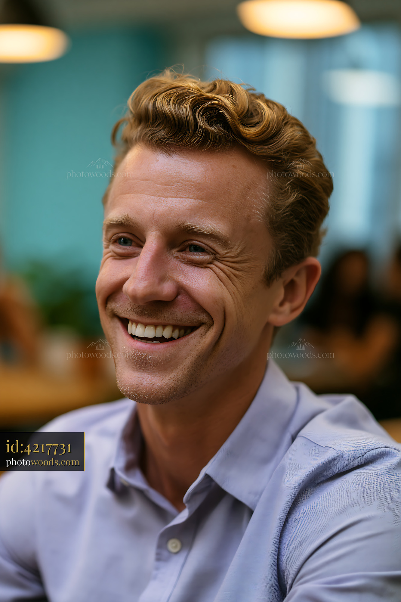 Man With Curly Hair Smiles Happily in a Bright Indoor Setting