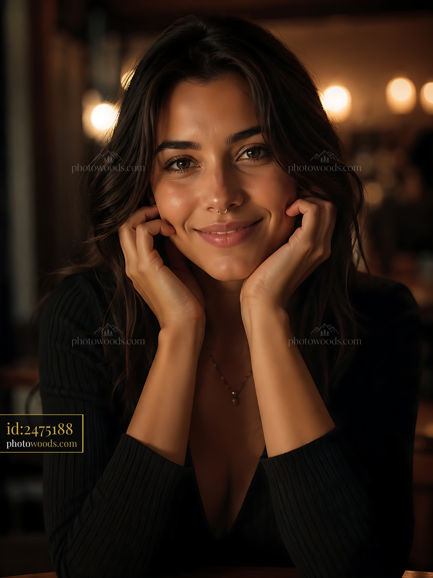 Woman Smiling With Hands on Face in Dimly Lit Cafe Setting