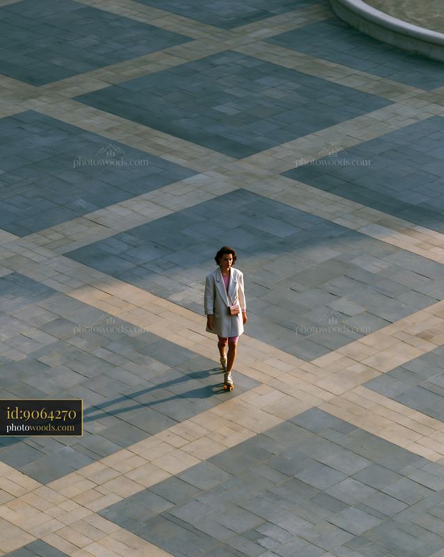 Woman in Oversized Blazer and Bike Shorts Walking on City Plaza