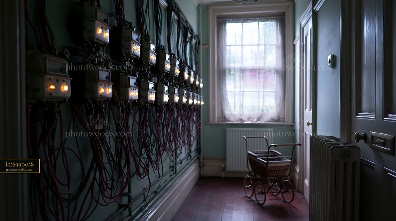 Dark Hallway With Tangled Electrical Meters and Vintage Stroller