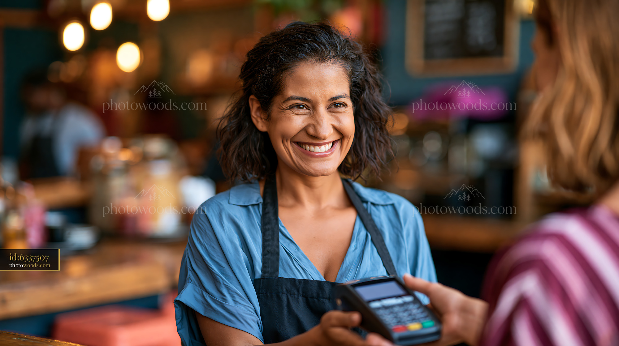 Professional Woman Smiling During a Payment Transaction in a Cafe