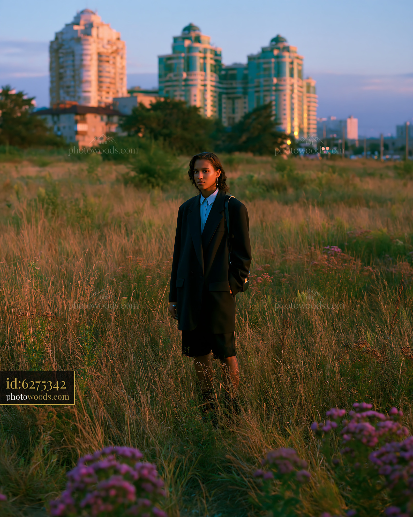 Woman in Oversized Blazer and Bike Shorts Standing in Field at Sunset