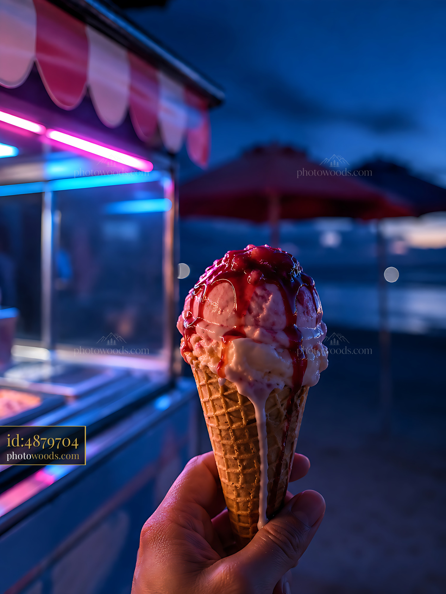 Ice Cream Cone Held at a Colorful Beach Stand at Night