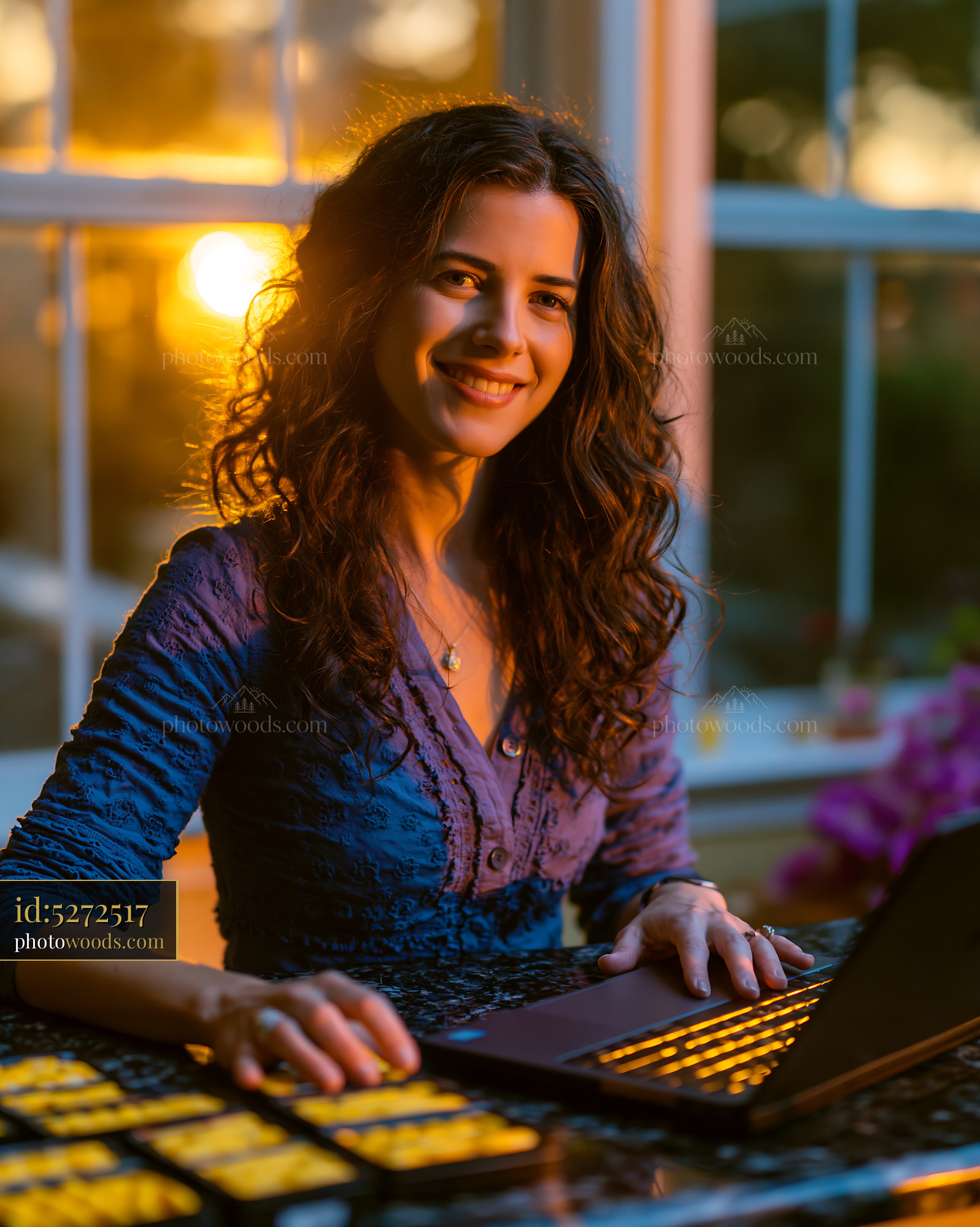 Woman Smiling While Working on Laptop During Sunset