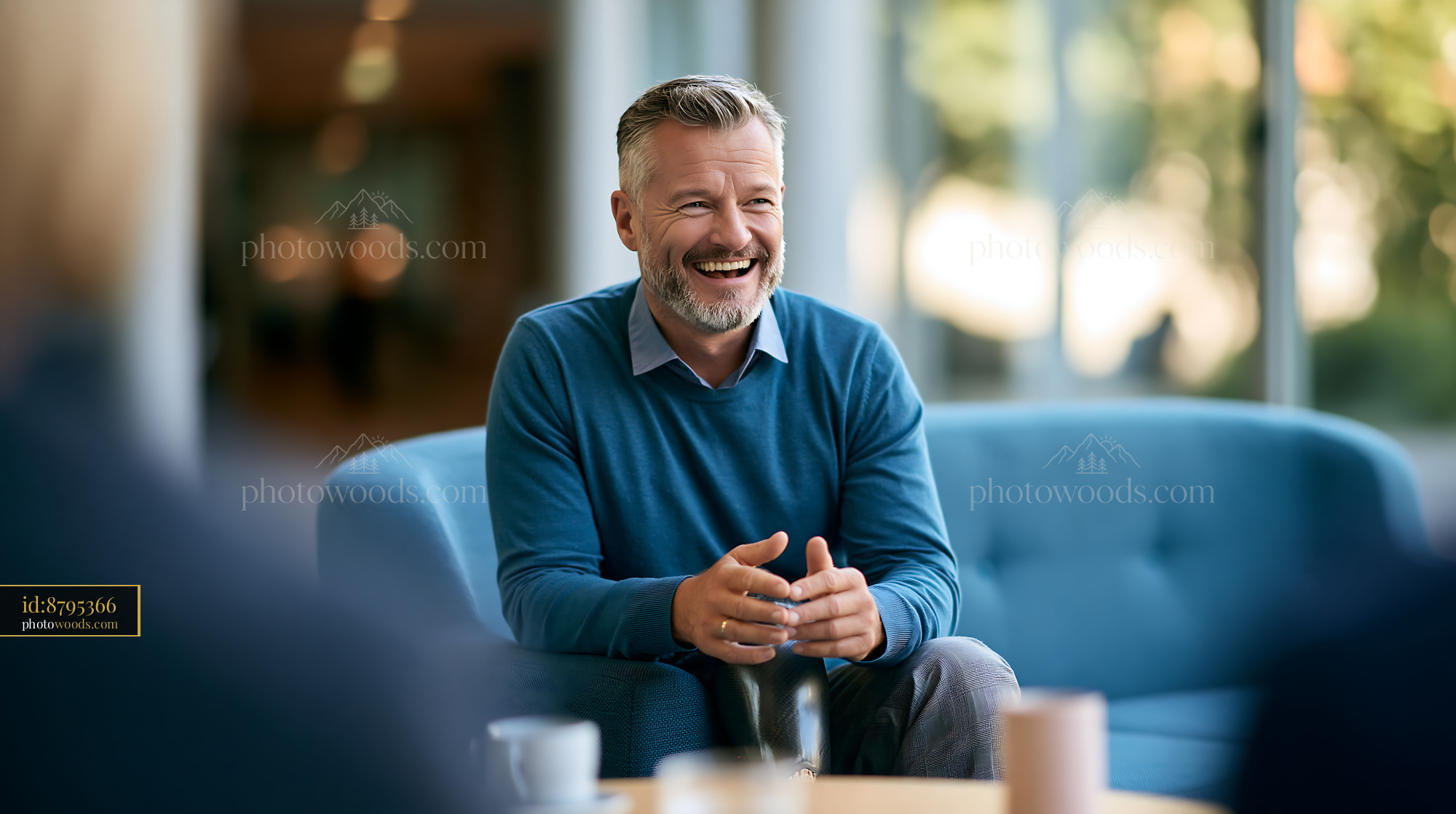 Cheerful Man With Prosthetic Leg Sitting on Blue Couch Smiling