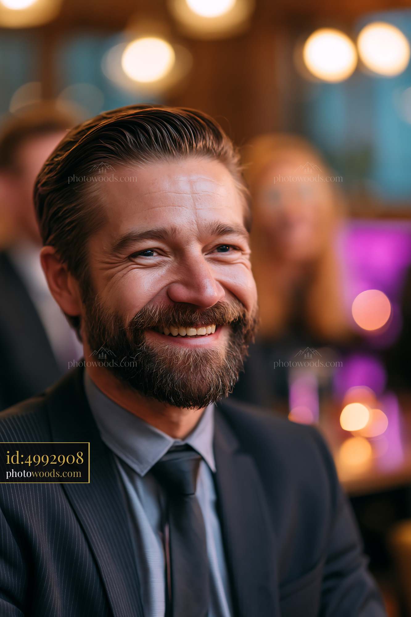 Man Smiling at a Gathering With People in the Background