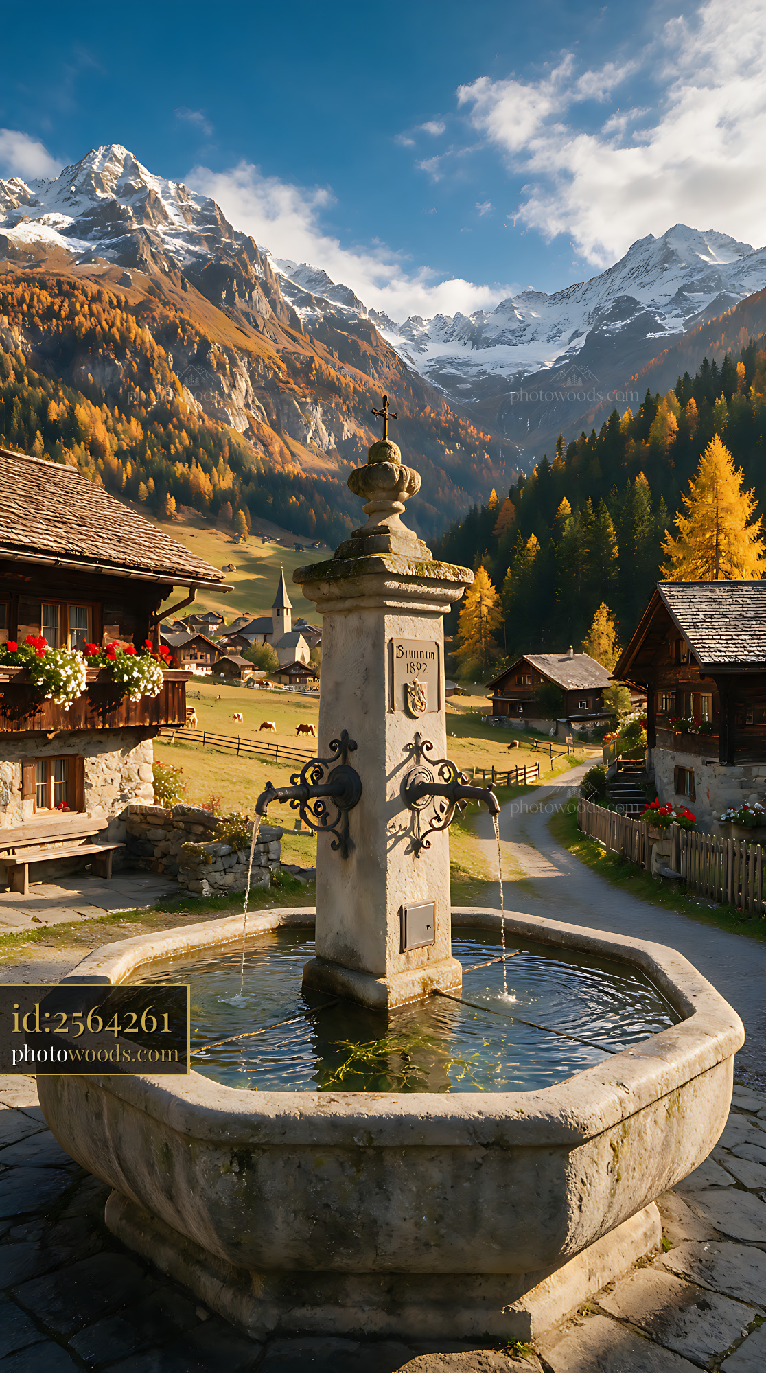Swiss village fountain with alpine mountain valley backdrop