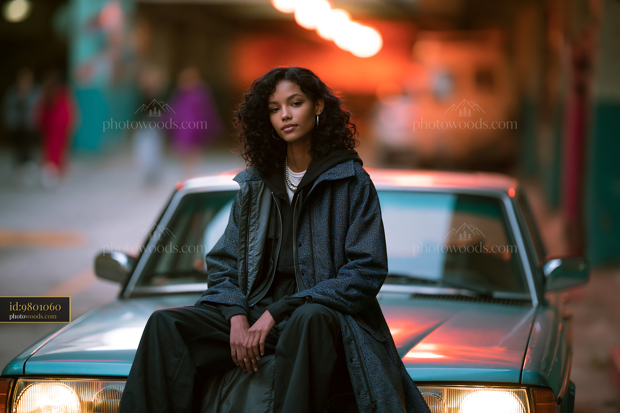Model Sitting on a Car in Urban Setting at Sunset