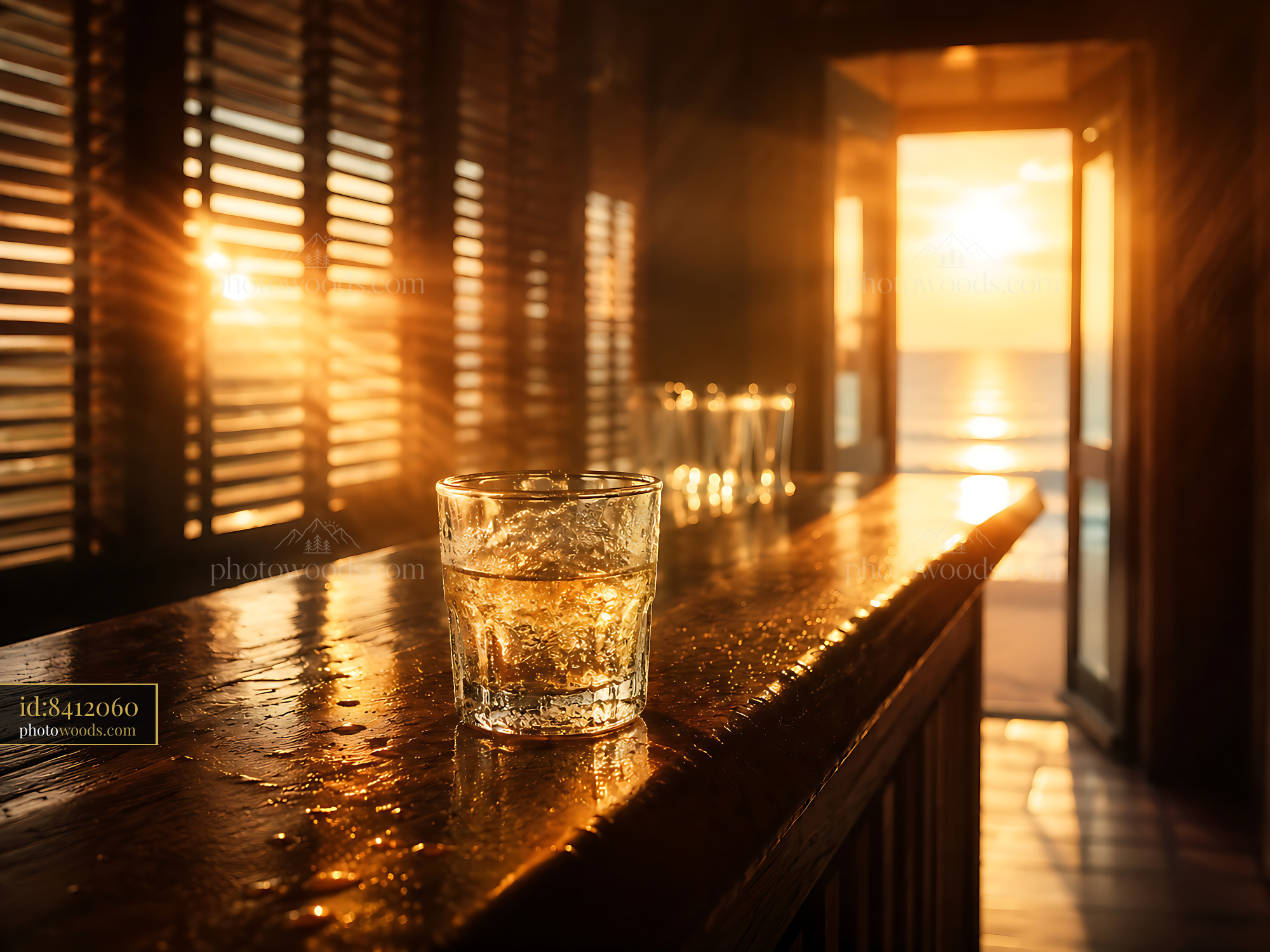 Glass of Water on Wooden Counter With Sunset View Over Ocean