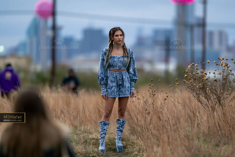 Model With Braided Hair in Acid Wash Outfit Standing in Field