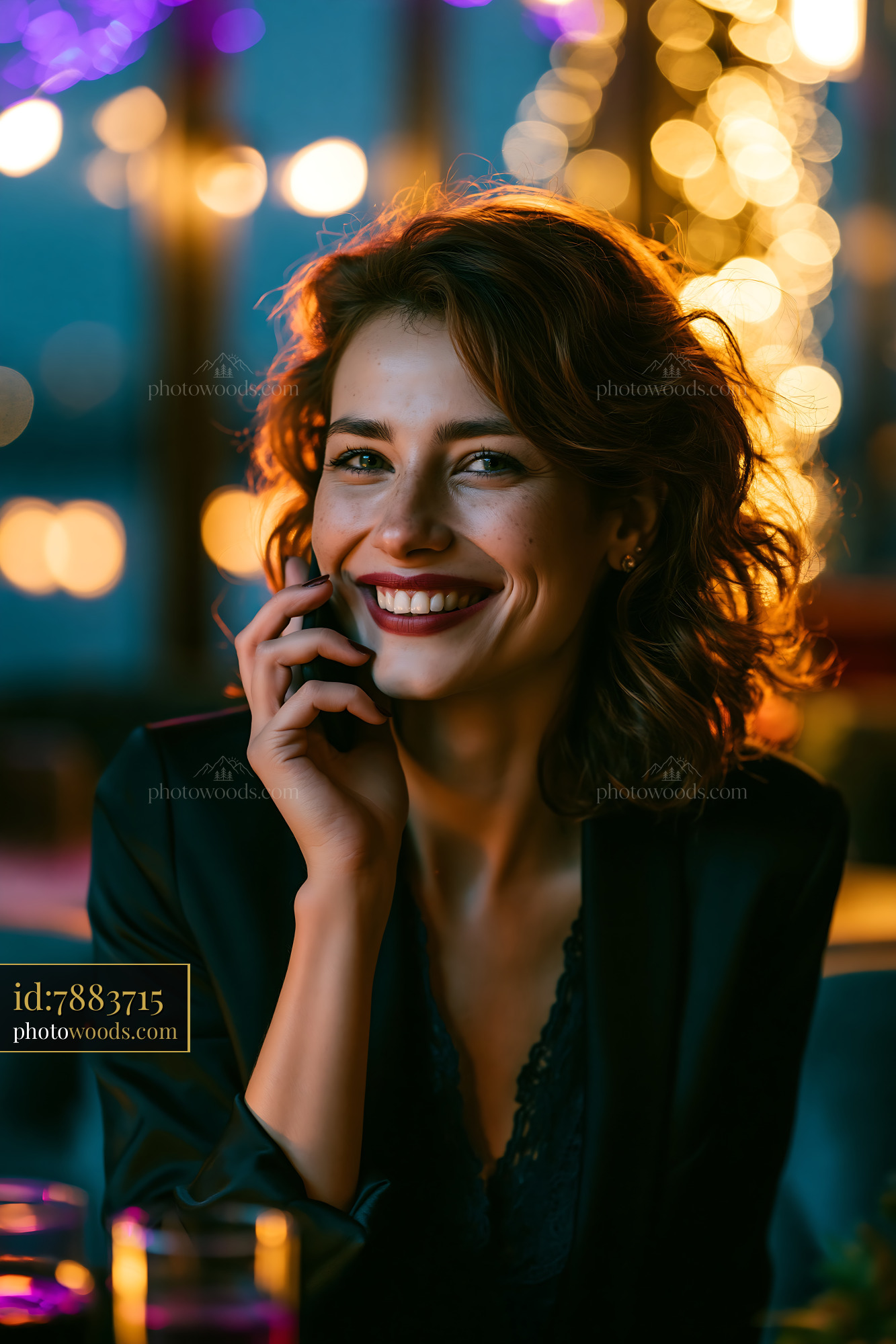 Woman Smiling While Talking on the Phone in a Dimly Lit Space