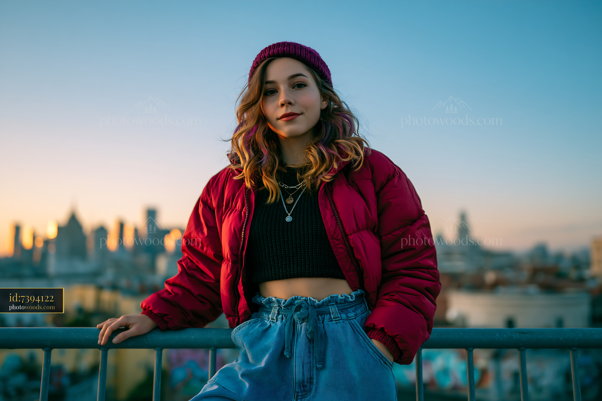 Striking Woman in Cropped Puffer Jacket Against City Skyline at Sunset