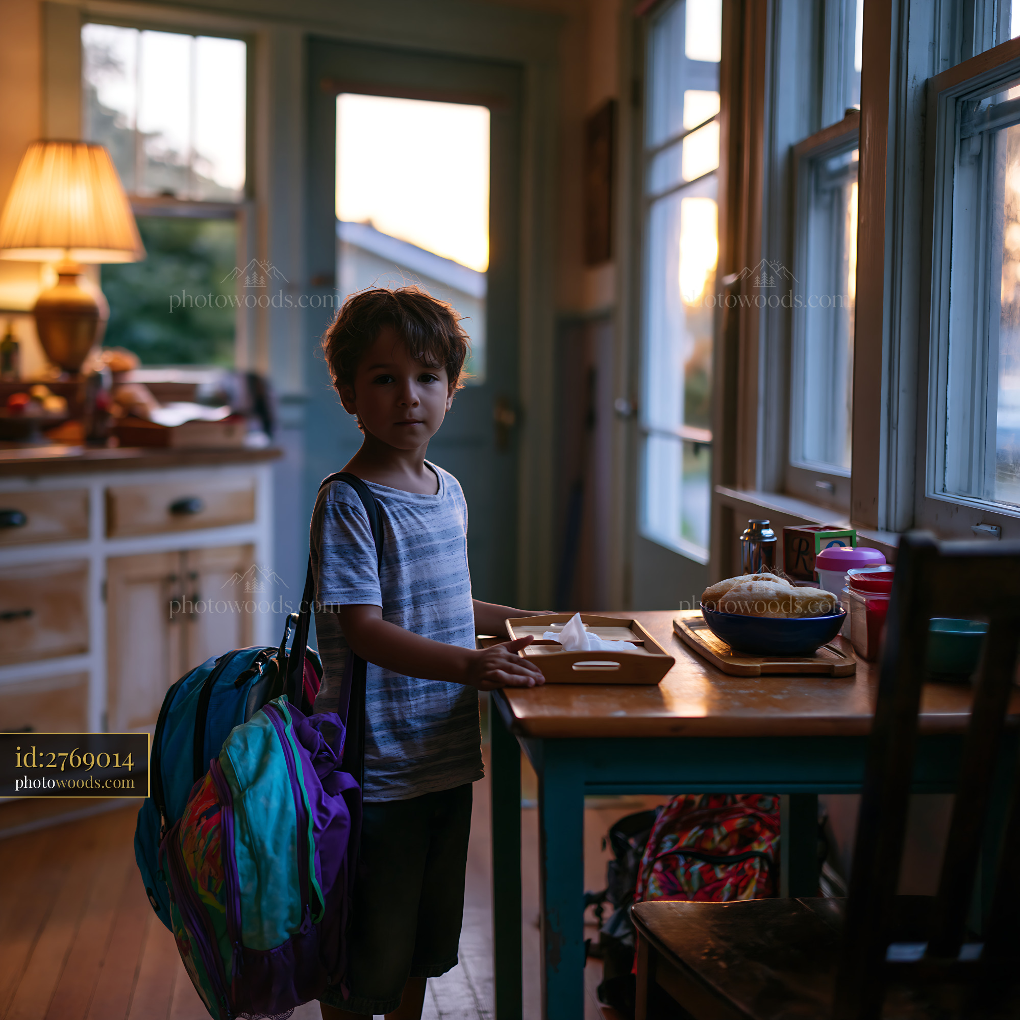 Child With Backpacks Standing in a Kitchen at Sunset