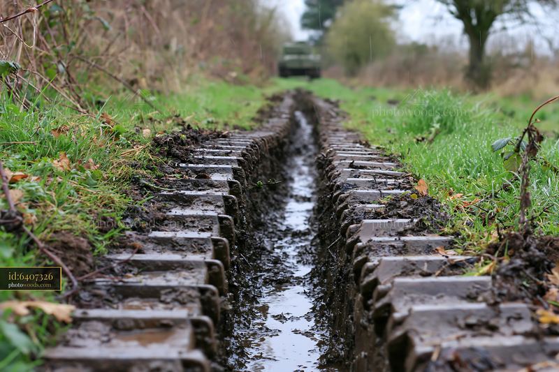 Close-up view of panzer tank tracks in mud and grass