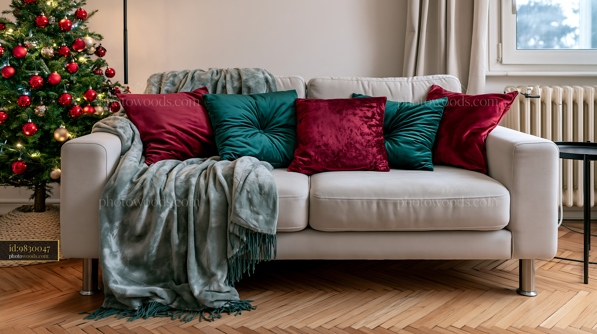 White sofa with blankets and colorful pillows beside a decorated Christmas tree in a bright living room.