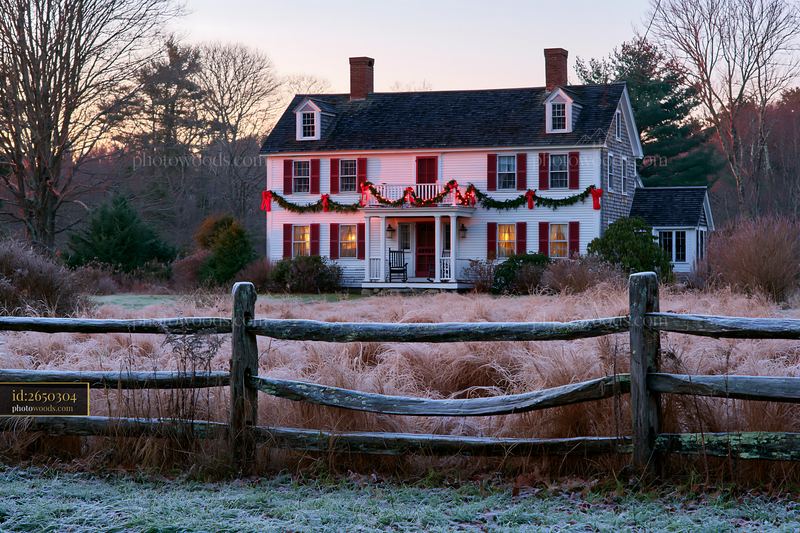 Traditional farmhouse decorated with holiday garlands at dusk