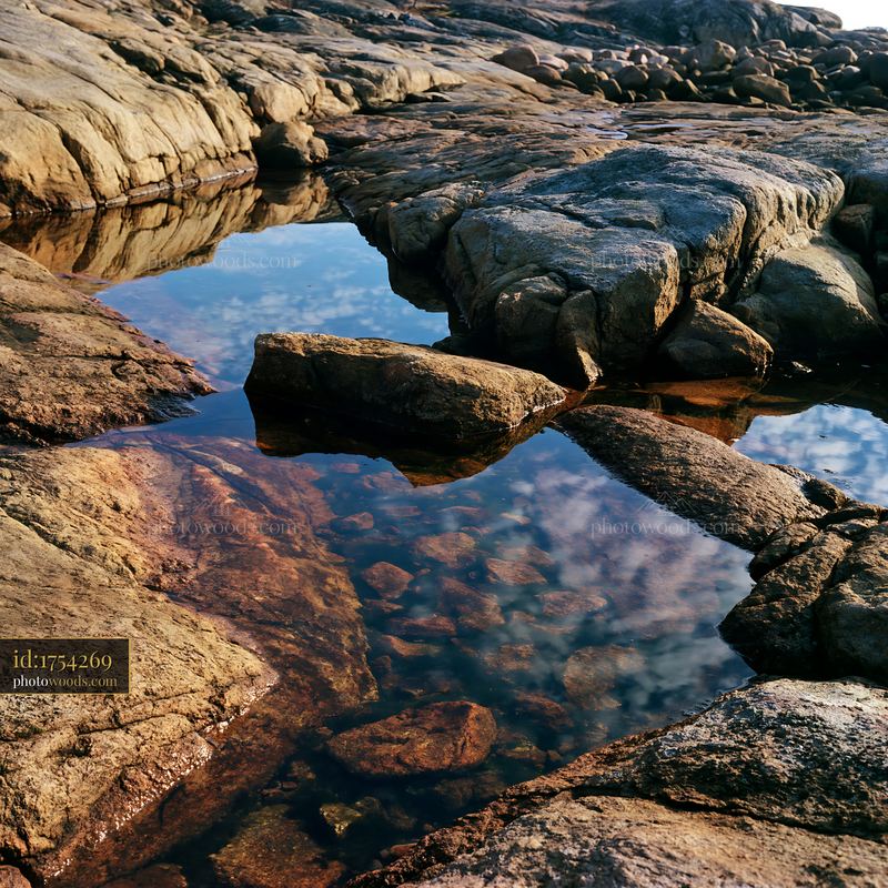 Coastline featuring exposed rocks and water reflections