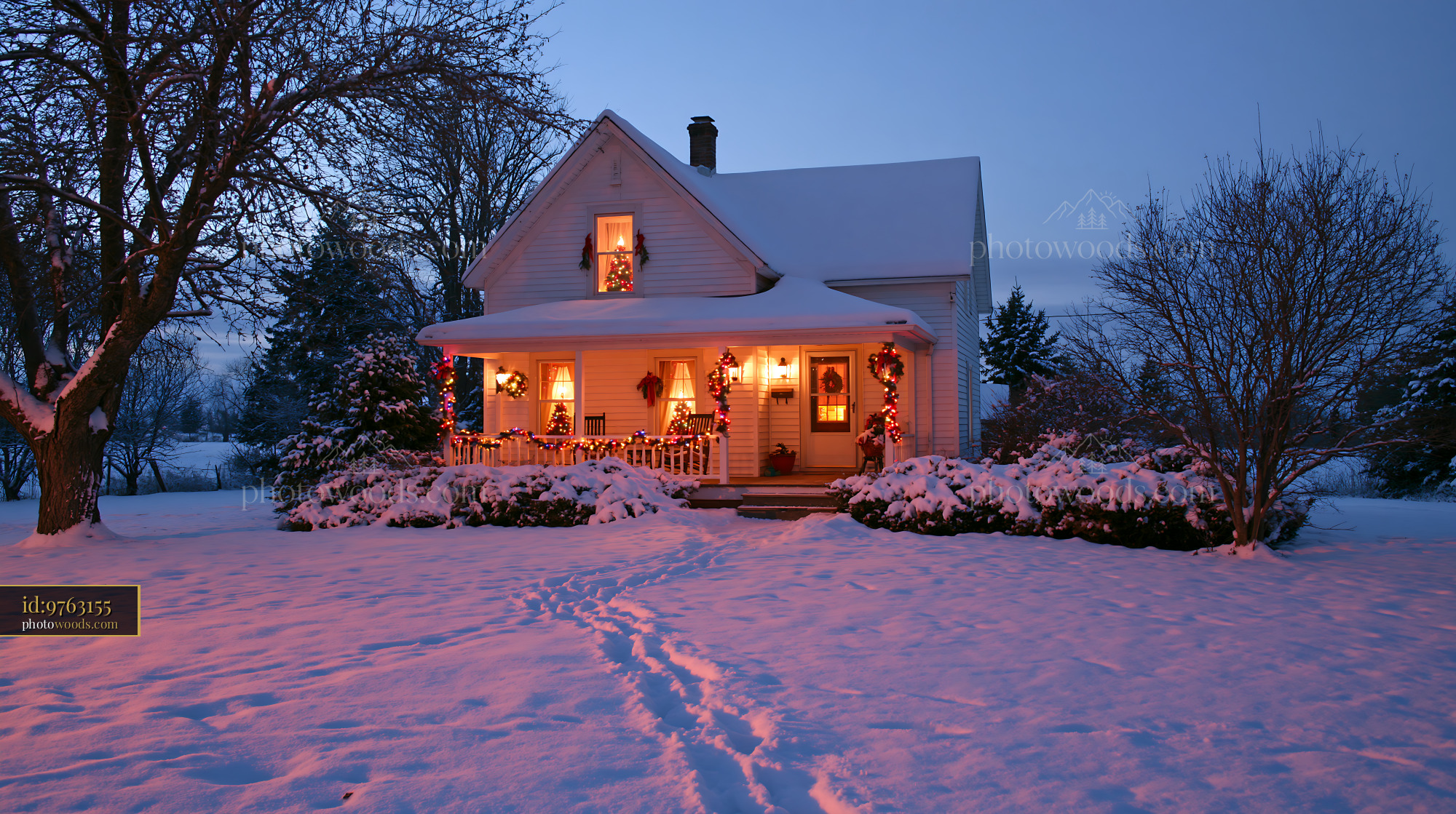 A country cottage with Christmas decorations stands in a snowy landscape at dusk.