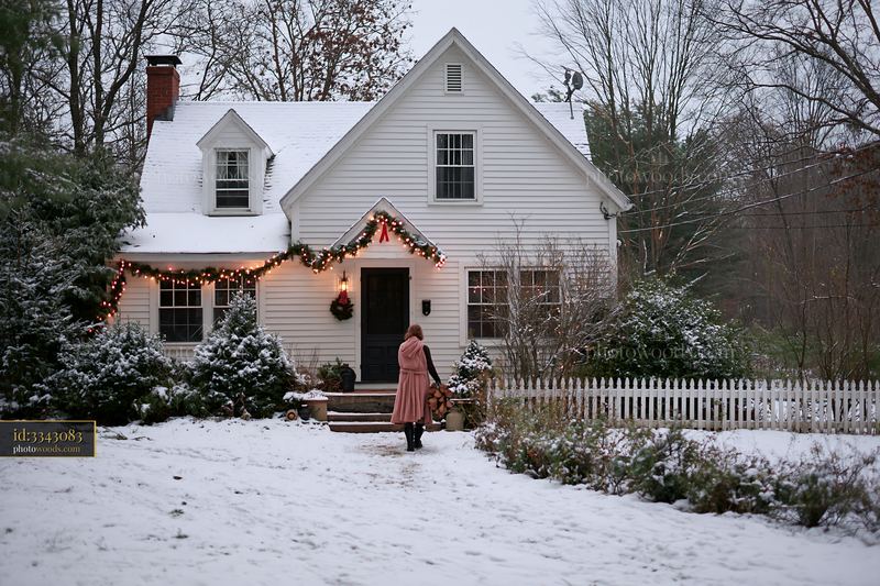 Snowy country house lit for Christmas with decorations and snow