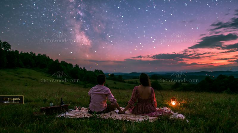 Couple watching stars while holding hands beneath the night sky