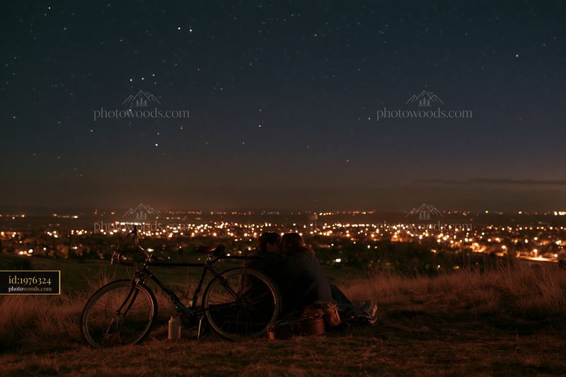 Couple enjoying a moment together under stars while wrapped in blanket